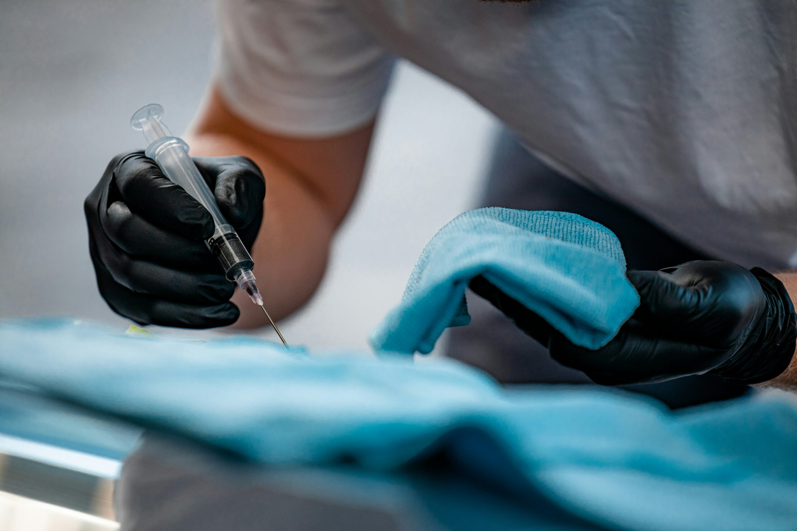Injection d'acide hyaluronique : seringue tenue par un médecin en gants, Paris 7